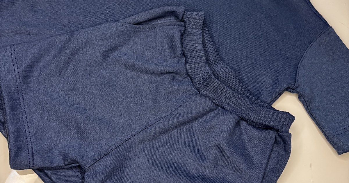 Blusa infantil Banim de modelagem oversize dobrada sobre fundo claro