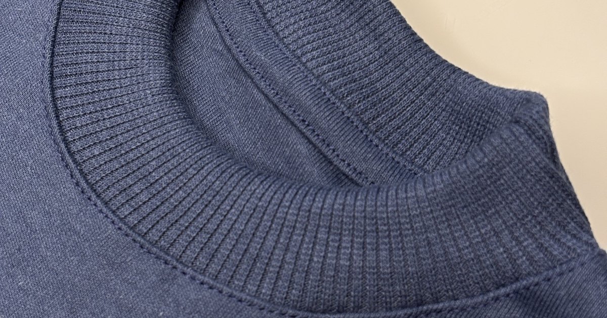 Close da gola canelada de uma blusa infantil Banim índigo, sem etiqueta interna